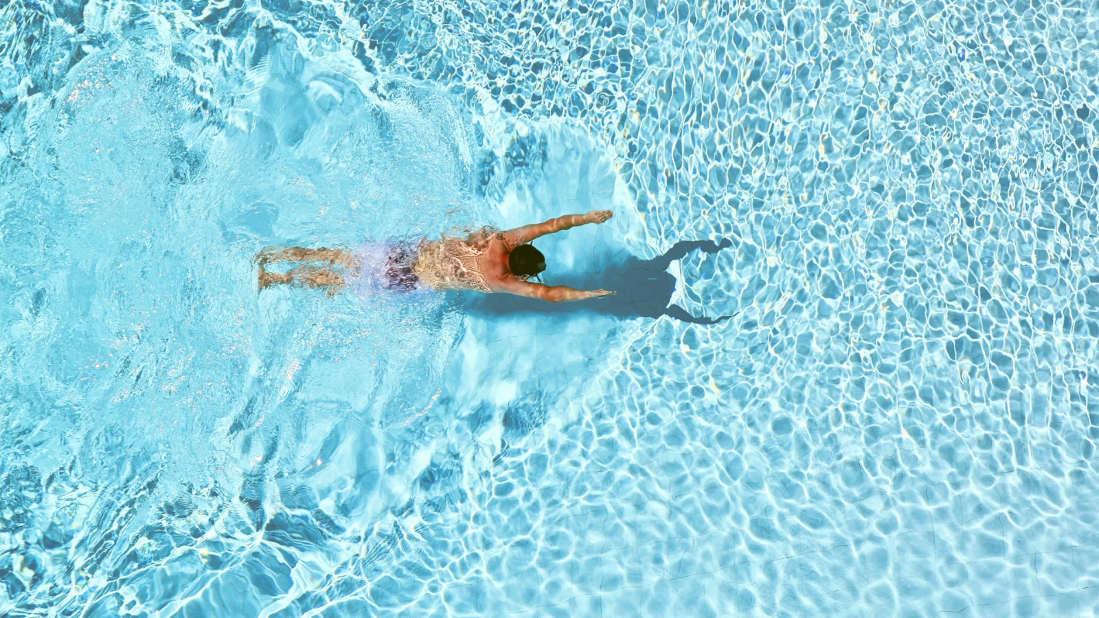 Person swimming in a pool while focusing on their breathing