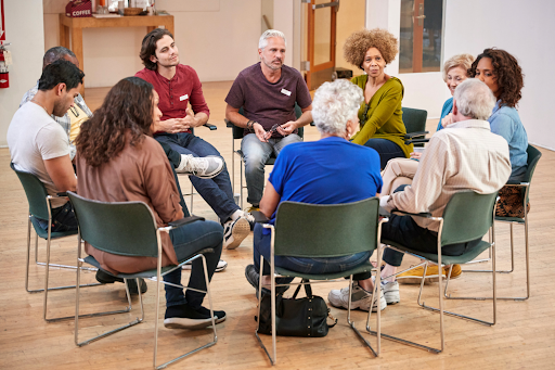 Gruppe von Senioren in Gesprächsrunde, die die Bedeutung von Gemeinschaft bei COPD zeigt.