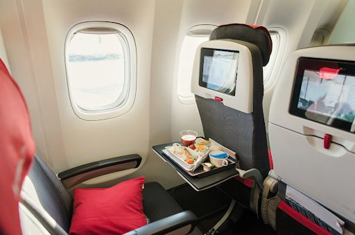 A meal on an open tray table inside a plane, emphasizing the need for COPD travelers to plan for in-flight comfort.