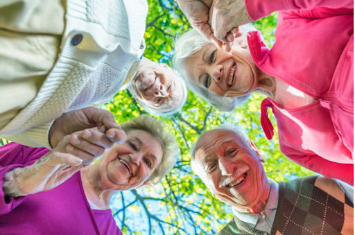 Eine Gruppe älterer Menschen, die lächelnd in die Kamera blicken, symbolisiert ein Gemeinschaftsgefühl und Unterstützung im Umgang mit COPD.