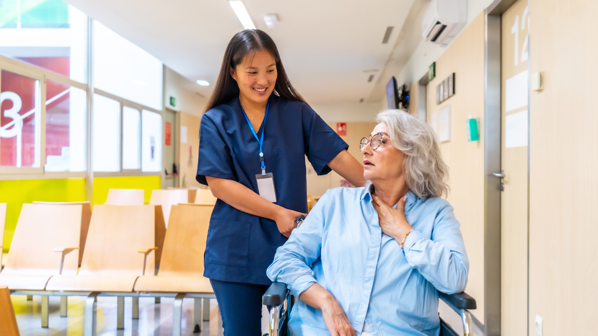 Nurse taking care of an elderly woman in a wheelchair with COPD symptoms.