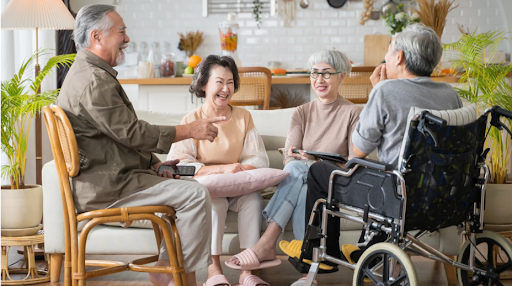 Freunde und Familie sprechen mit einem COPD-Patienten im Rollstuhl und betonen die Rolle informeller Pflegepersonen.