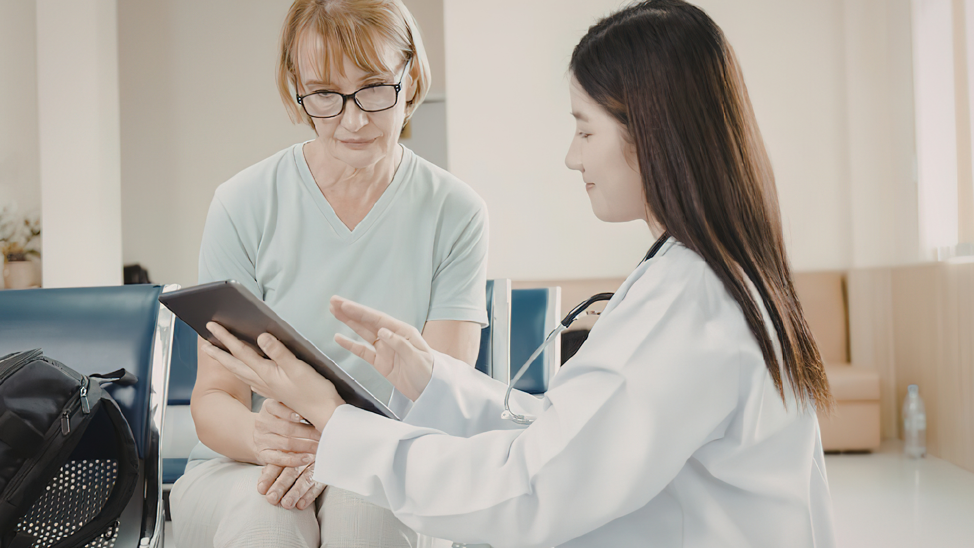 Person reviewing lung health medical results tablet with a doctor.