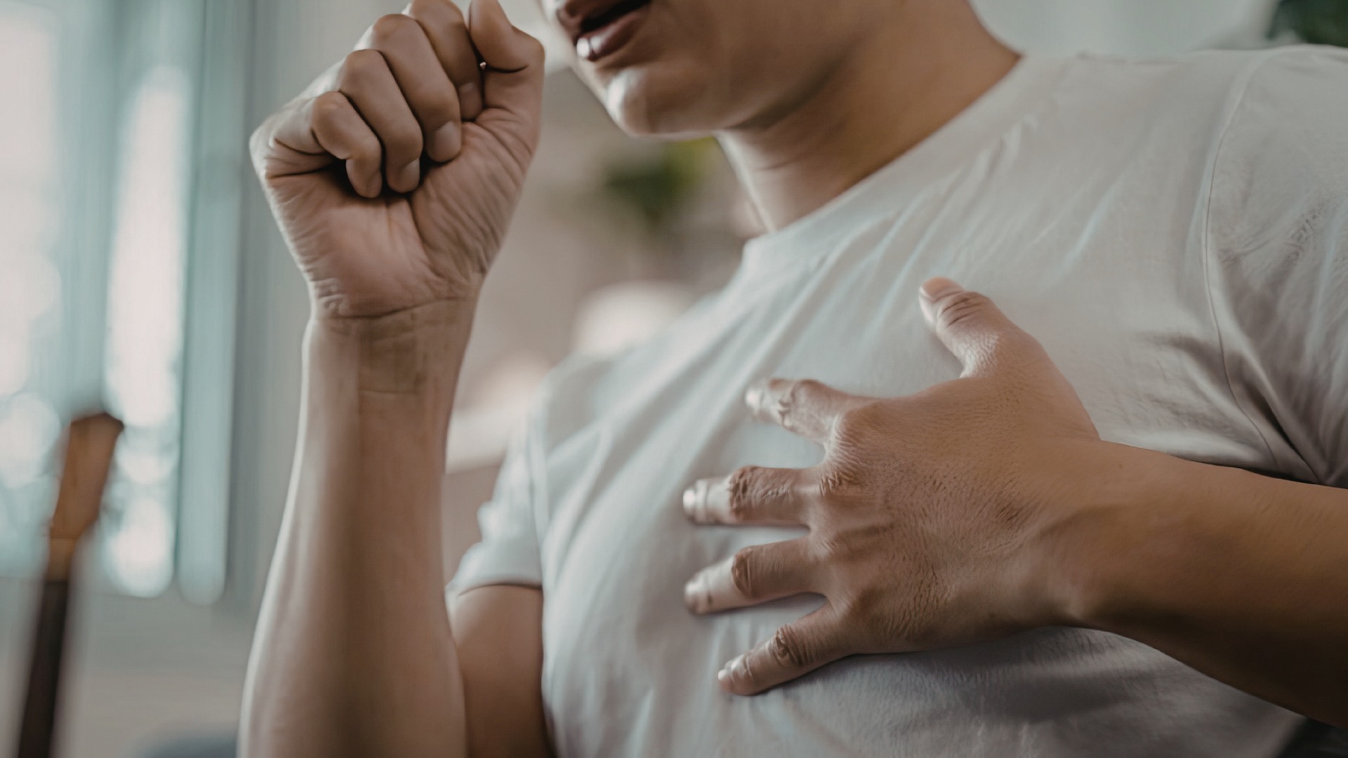 Adult noticing early breathing discomfort and paying attention to lung health.