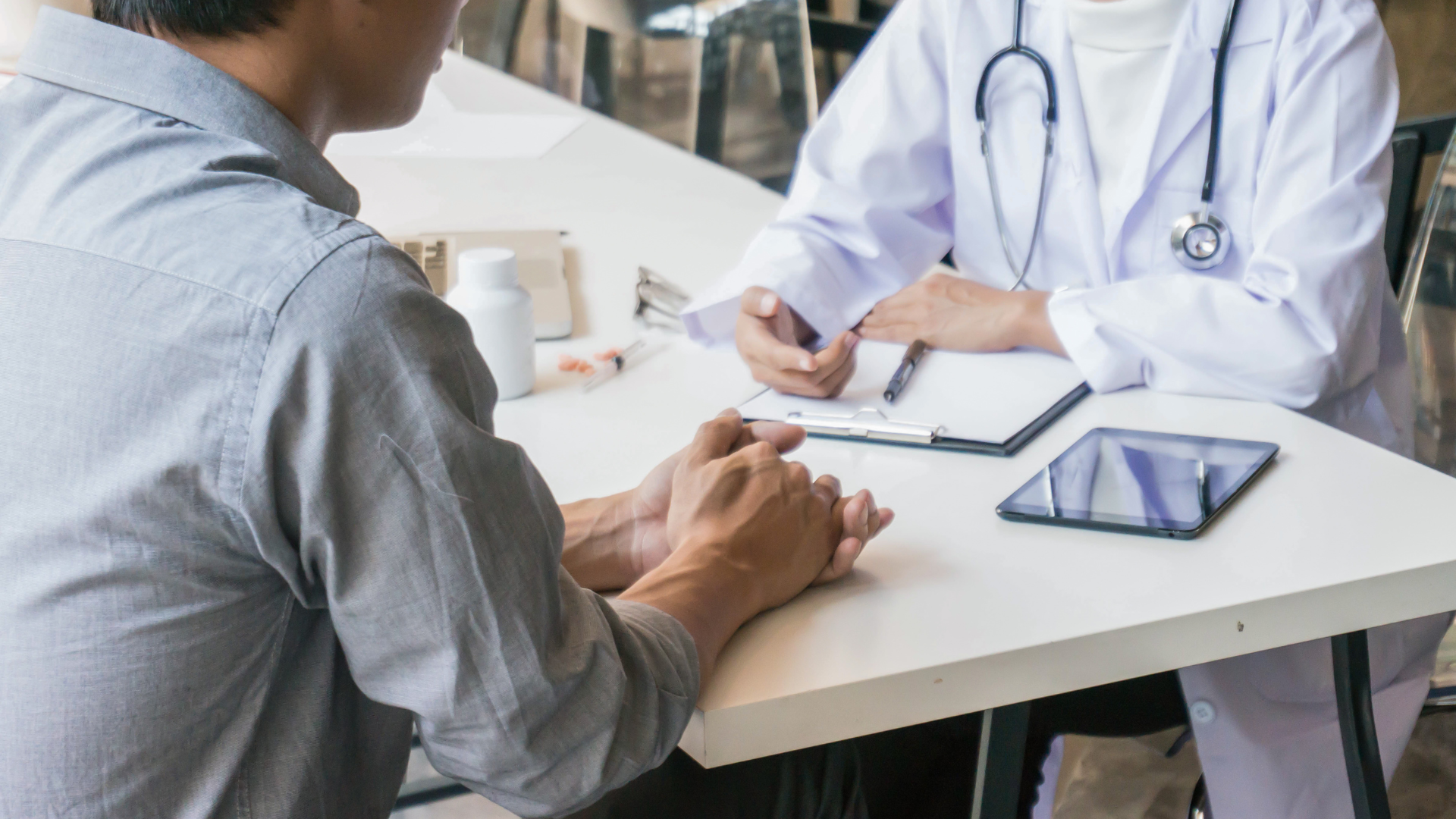 Adult discussing lung cancer screening eligibility with a doctor in a calm medical setting.