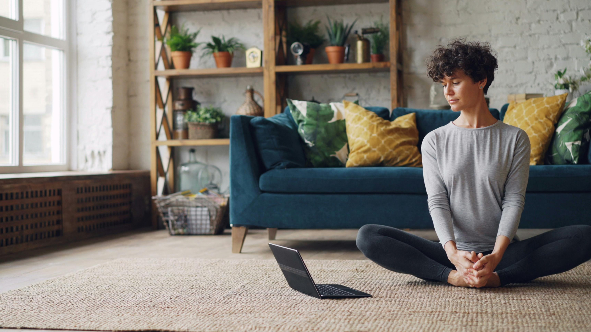 Person doing gentle stretching and breathing exercises in a calm indoor space.