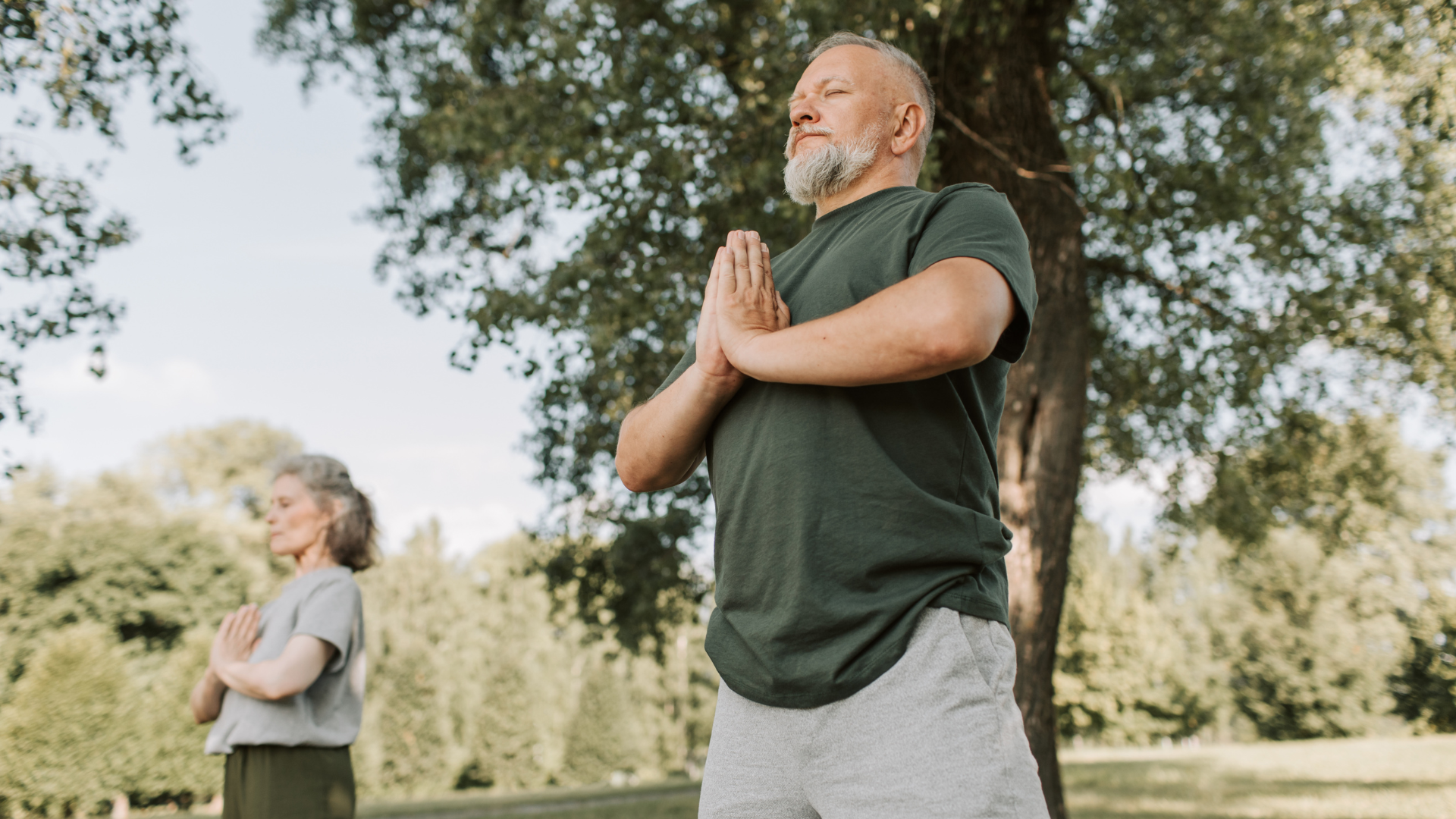Person practicing calm movement and breath awareness outdoors in a relaxed setting.