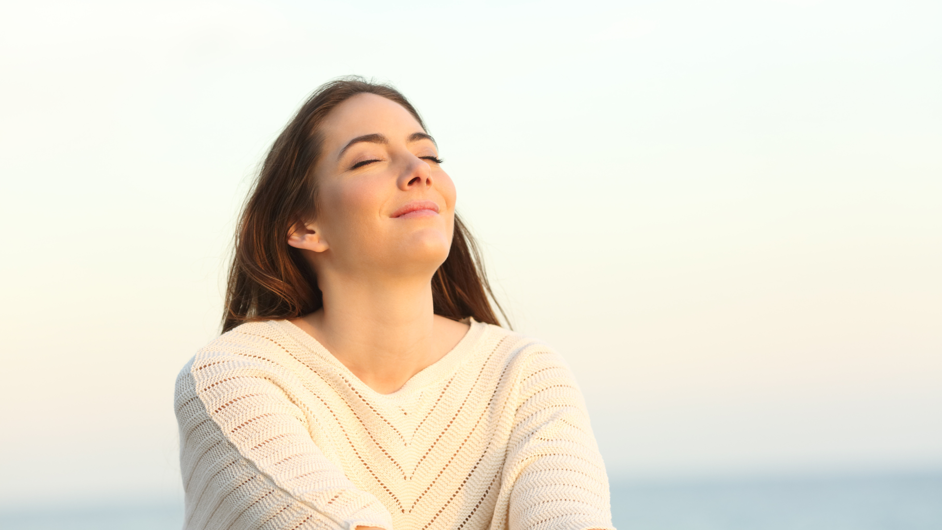 Woman enjoying a calm breath in warm summer light.