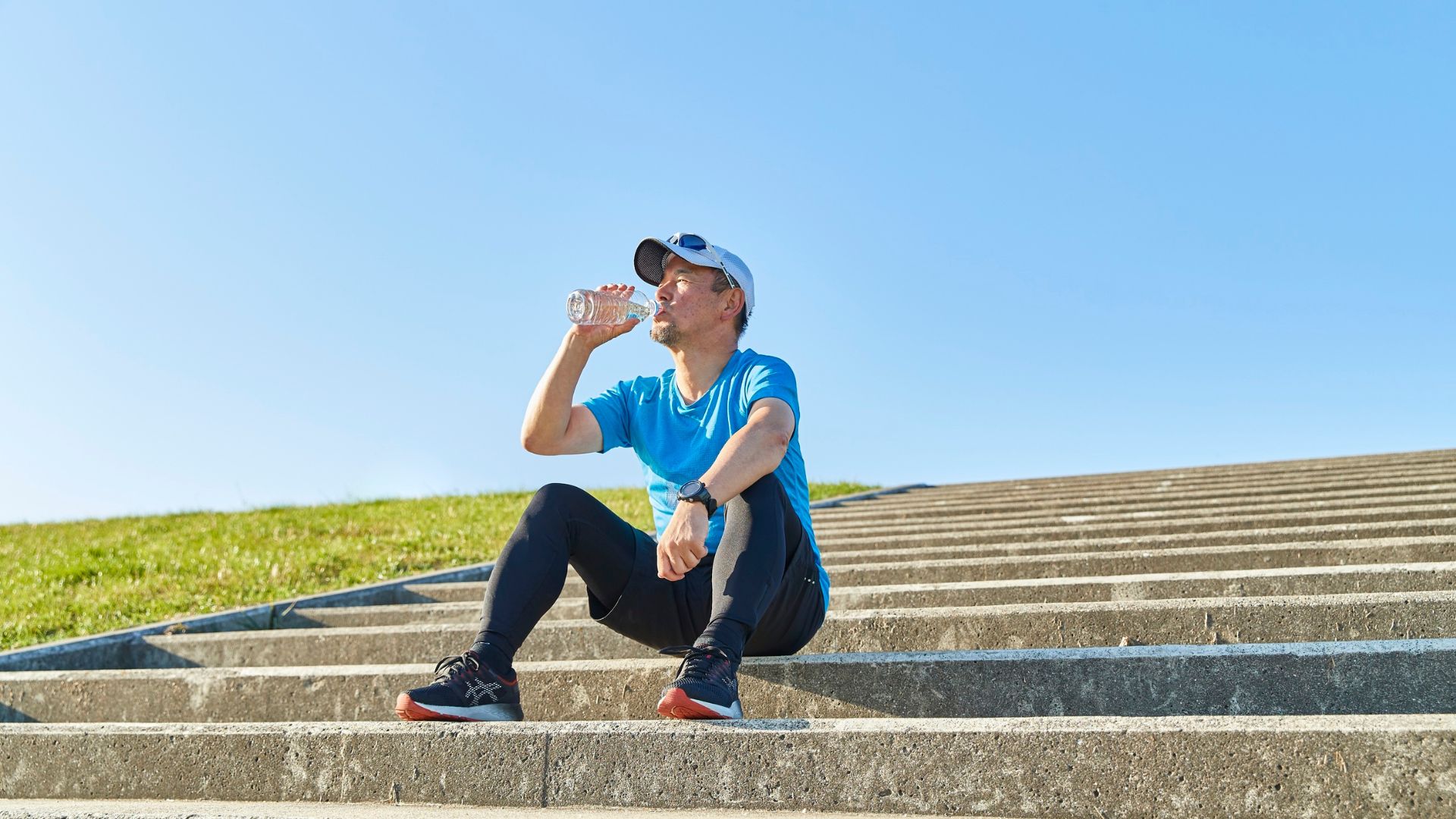 Mann trinkt bei heißem Wetter während einer Trainingspause Wasser