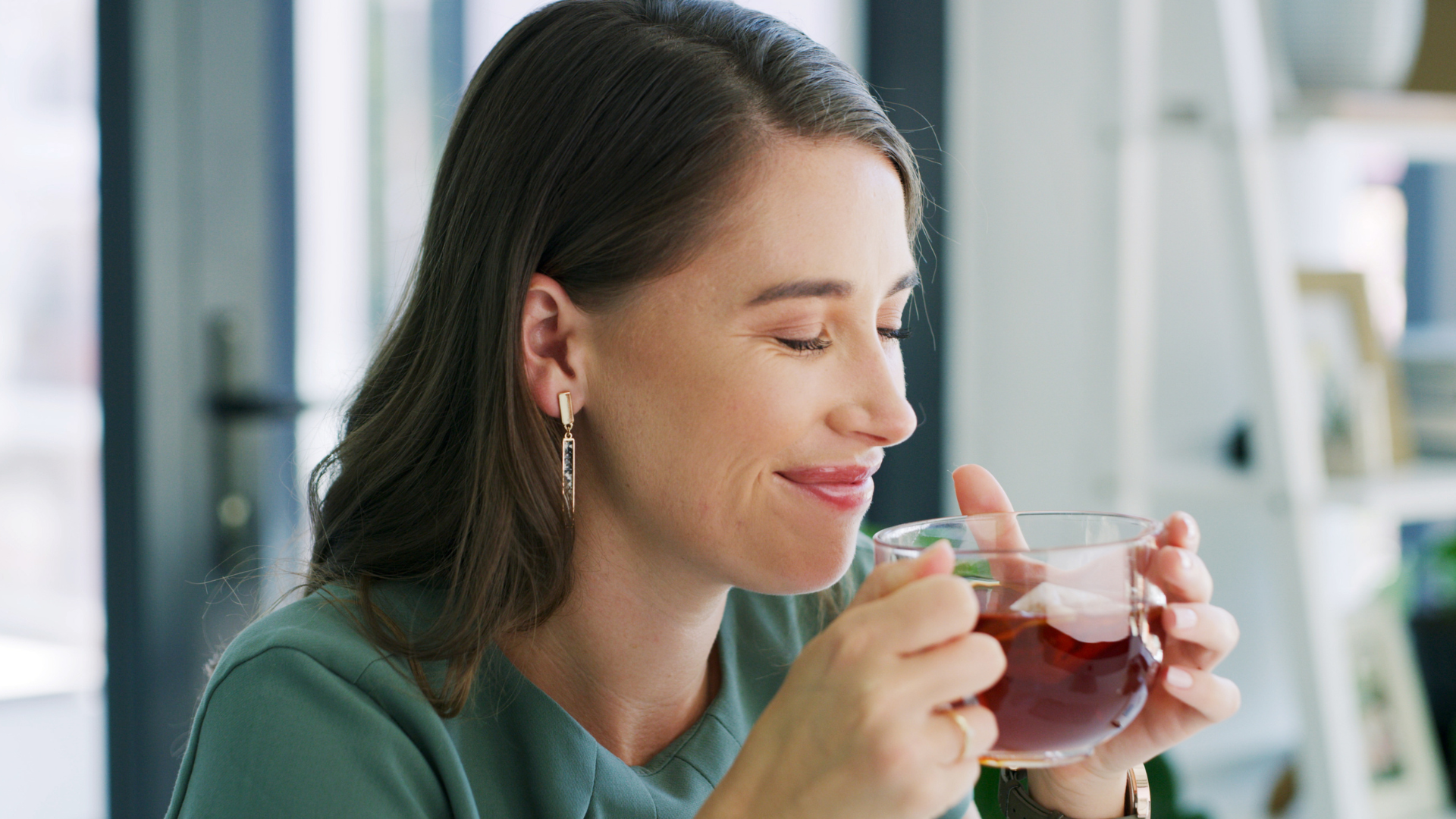 Woman replacing a smoking habit with tea during smoking cessation.