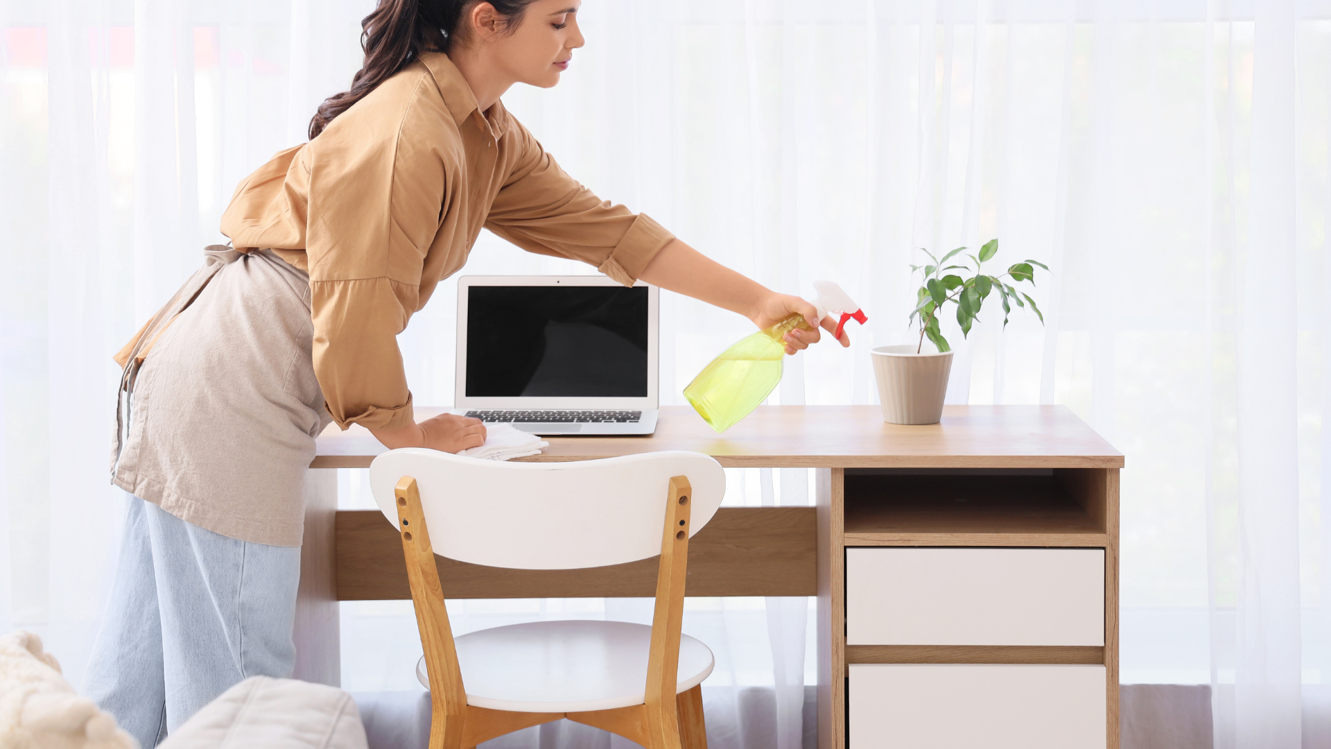 Woman cleaning her home of pollen particles with a cloth to maintain a cleaning routine.