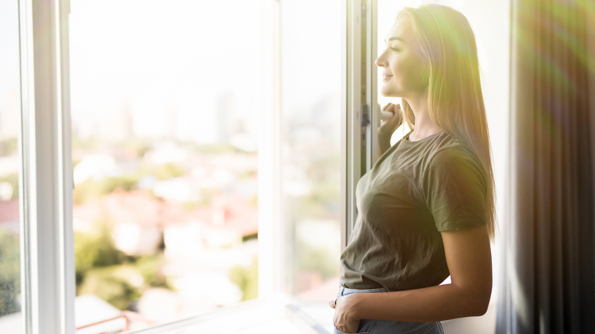 Person looking outside through an open window while managing asthma.